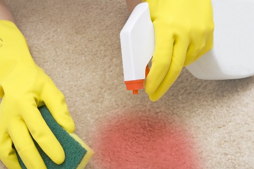 Professional carpet cleaner treating a carpet in a W14 home